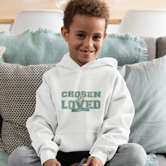 Child wearing a hoodie with 'Chosen & Loved' text, sitting on a couch.