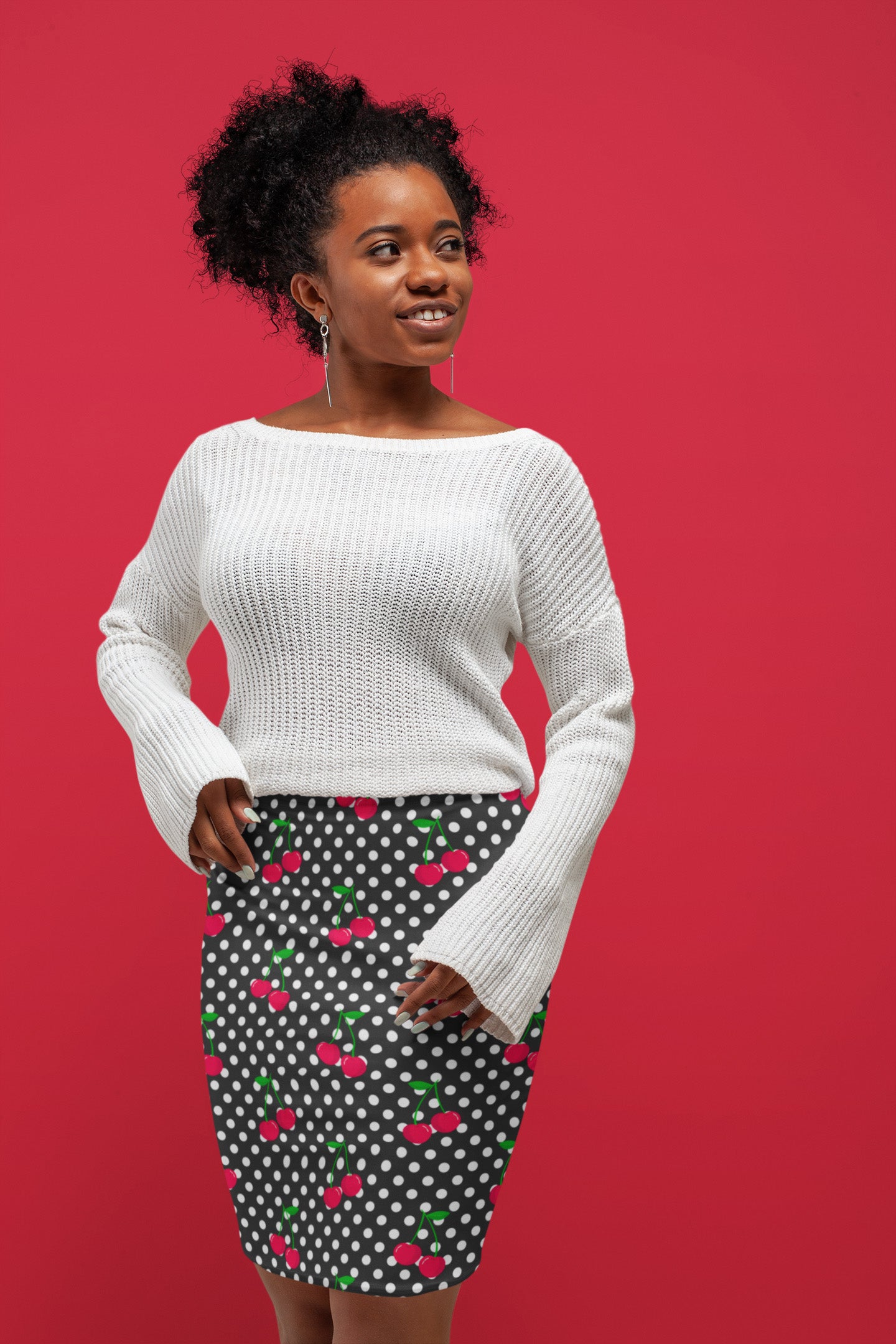 Woman wearing a white sweater and polka dot skirt with red background