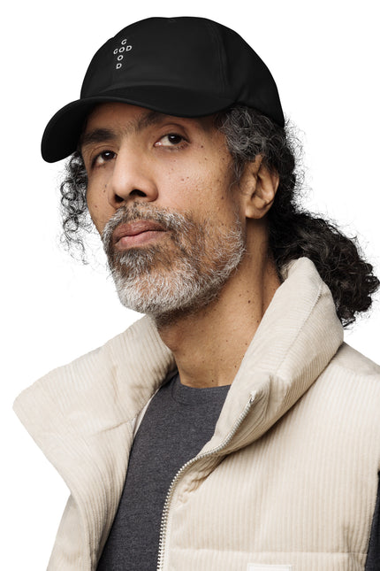 Man wearing a black cap and beige vest on a white background