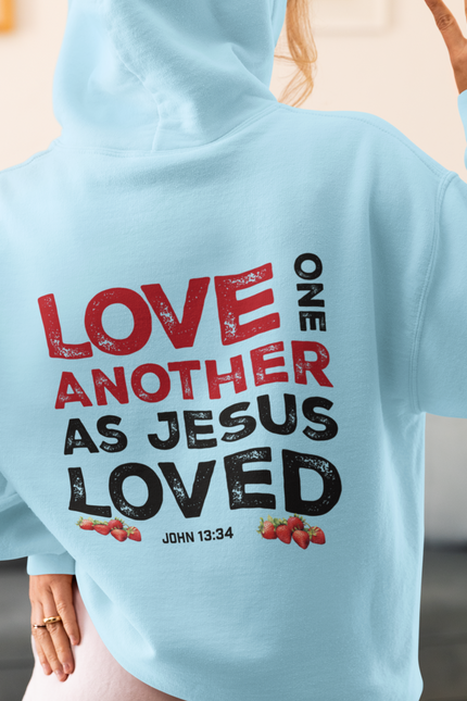 Light blue hoodie with text 'Love one another as Jesus loved' on the back, worn by a person.