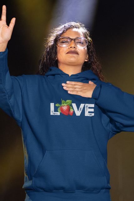 Person wearing a blue hoodie with 'LOVE' and a strawberry graphic, standing against a dark background.