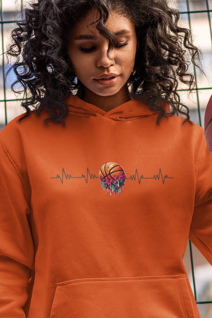 Person wearing an orange hoodie with a colorful basketball design, holding a basketball.